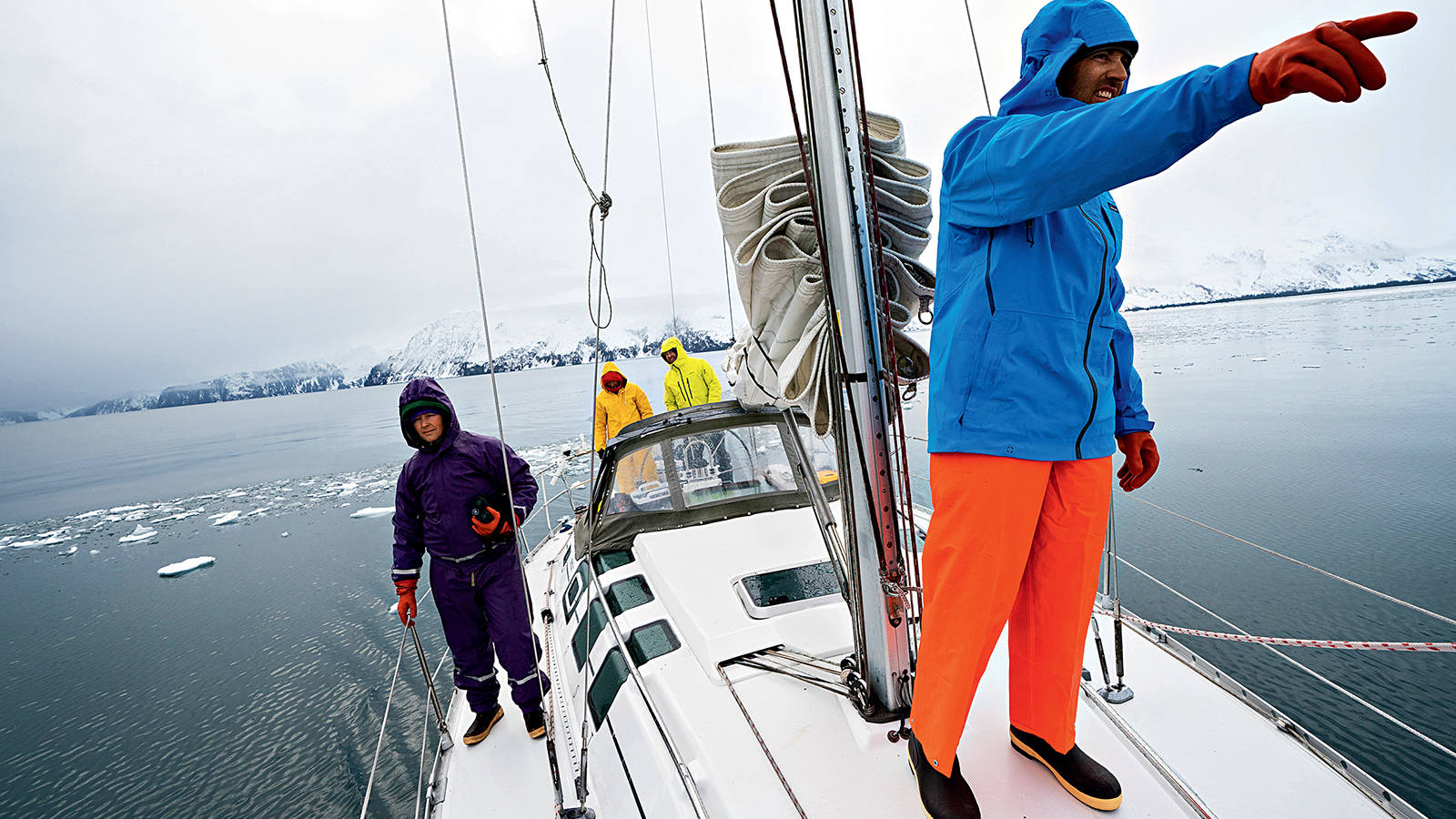 <p>Captain Nathan Straubinger (at the helm) steers the 35-foot Madrona through the ice on Aialik Bay as Chaney (pointing), Griffith and Baldwin Goodell serve as lookouts. Though the group had hoped that much of the distance could be covered with sails unfurled, the winds were frequently too light. Boating still turned out to be a low-carbon method of travel, requiring only about 30 gallons of diesel for the 10-day trip.</p>