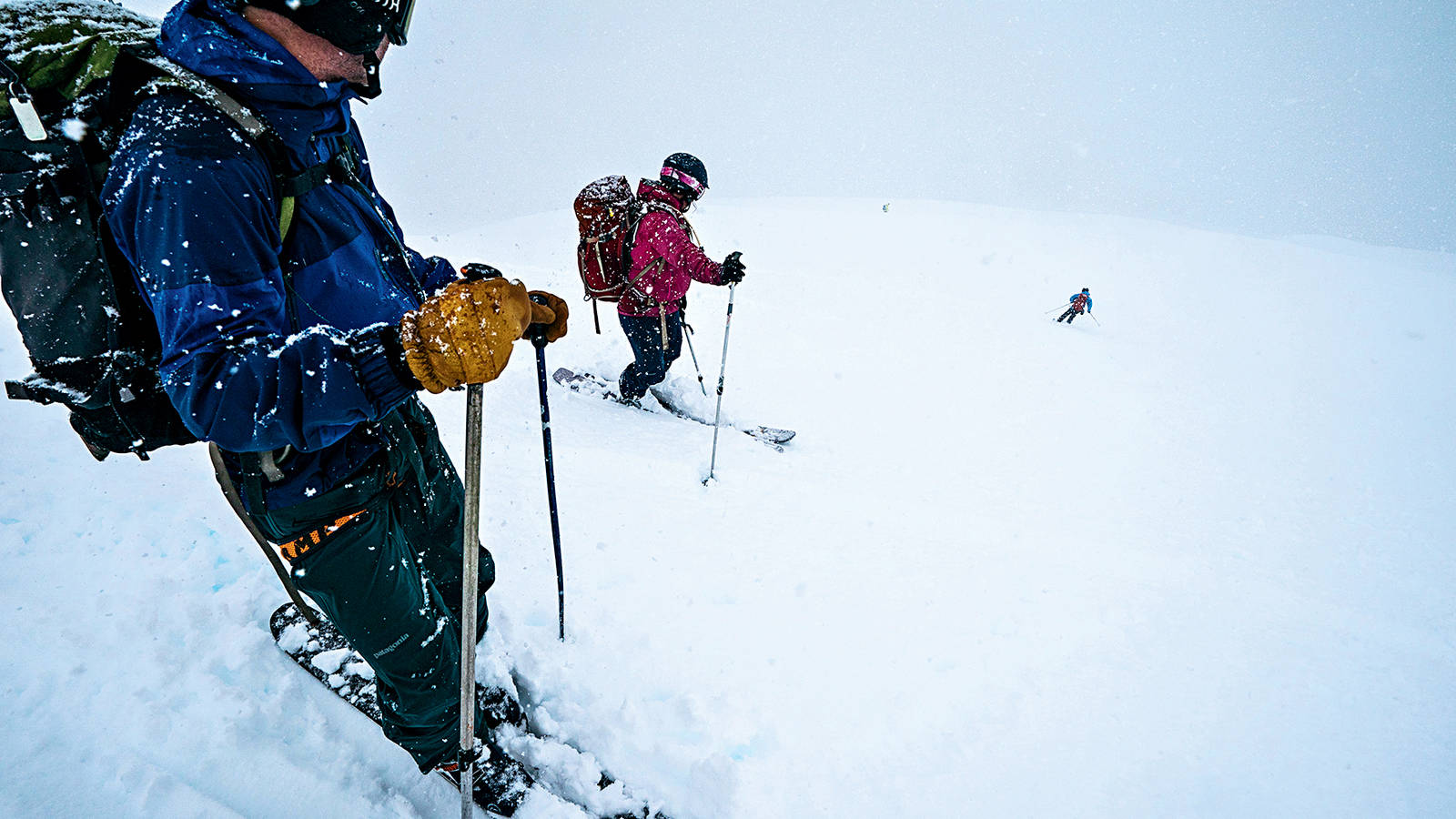 <p>Goodell and Griffith watch as Chaney skis in near-whiteout conditions above Aialik Bay. Snowstorms, while expected, occasionally changed the group’s well-crafted plans. On one particularly treacherous day, they built a small snow cave on the side of a mountain to wait out a squall. </p>