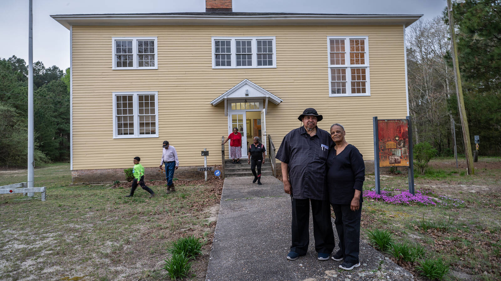 <p>Rudolph and Sylvia Stanley, accompanied by members of their family, stand in front of the San Domingo School. The couple, who have been married for 51 years, attended the school as children. </p>