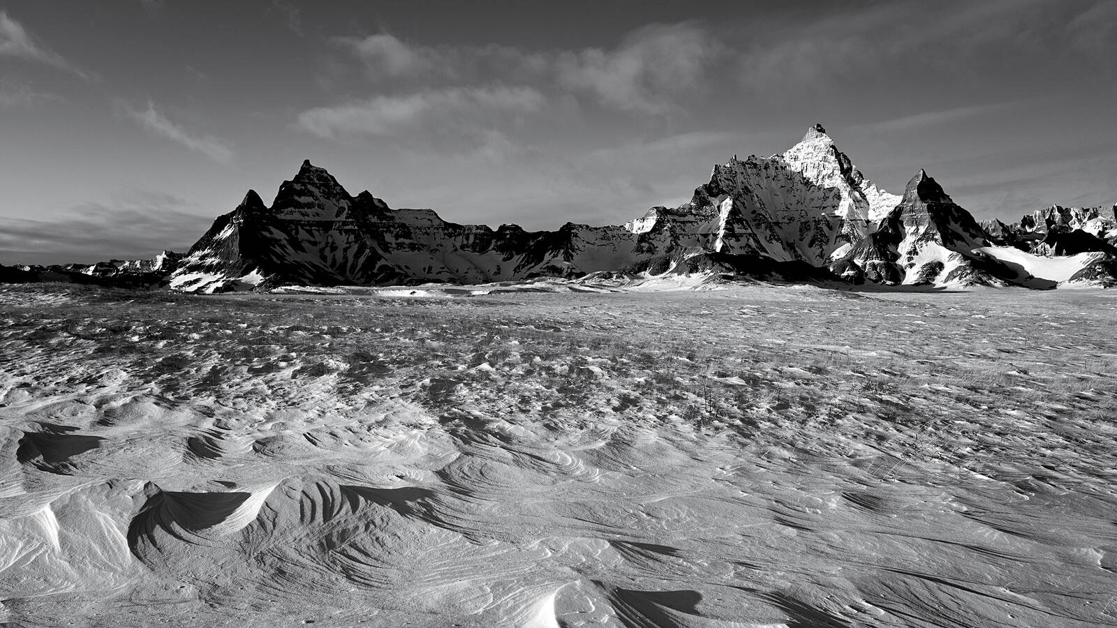 <p>Wind-carved snowdrifts stretch toward rocky pinnacles near the Ben Reifel Visitor Center.</p>