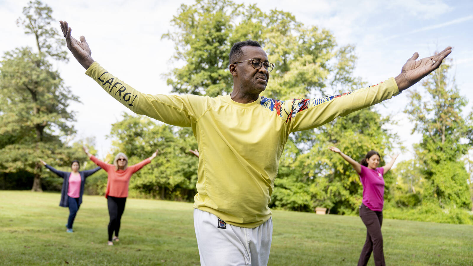 <p>A tai chi class practices in the park.</p>